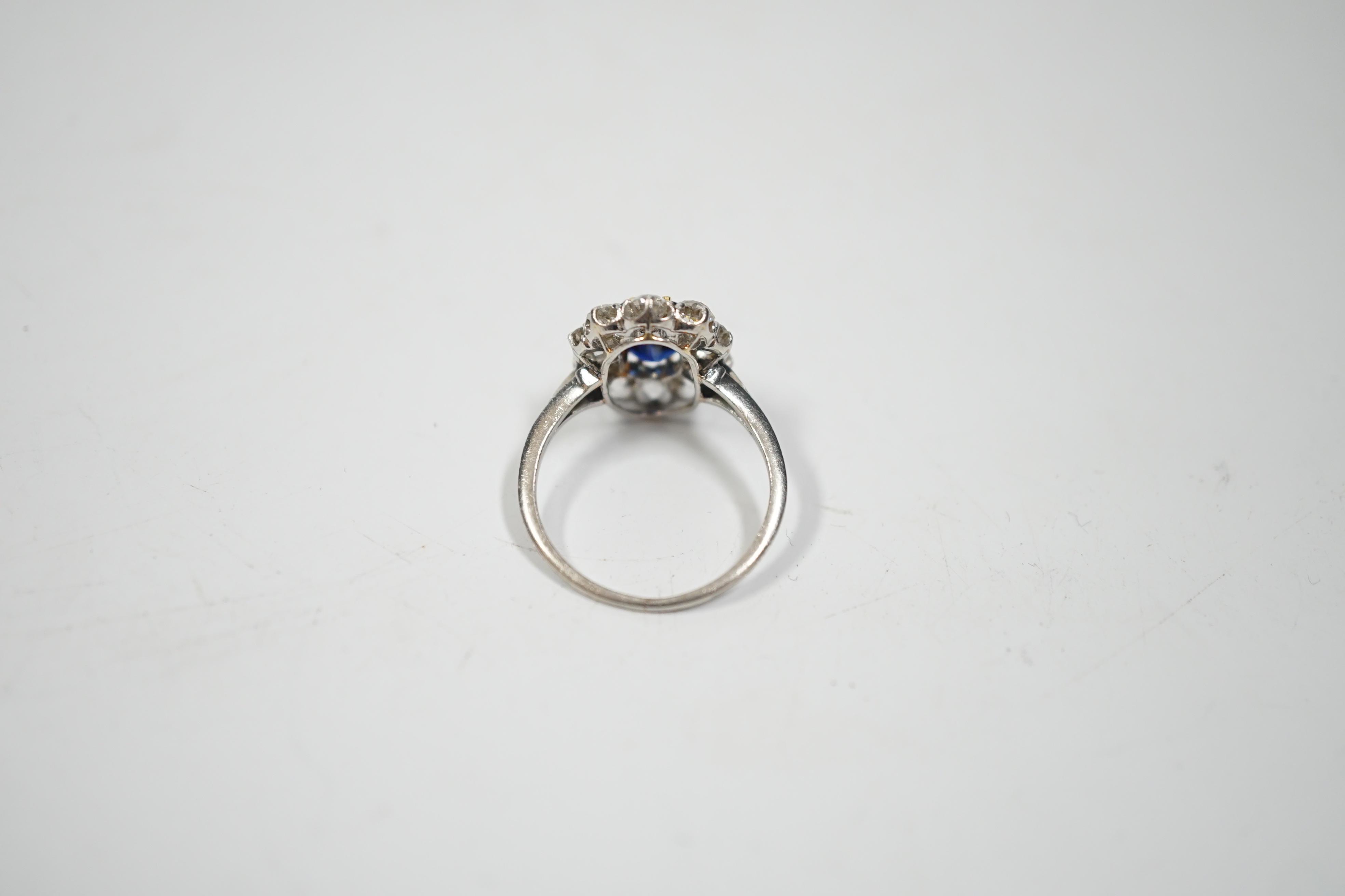 A white metal, synthetic sapphire and diamond set oval cluster ring, size M, gross weight 3.8 grams.